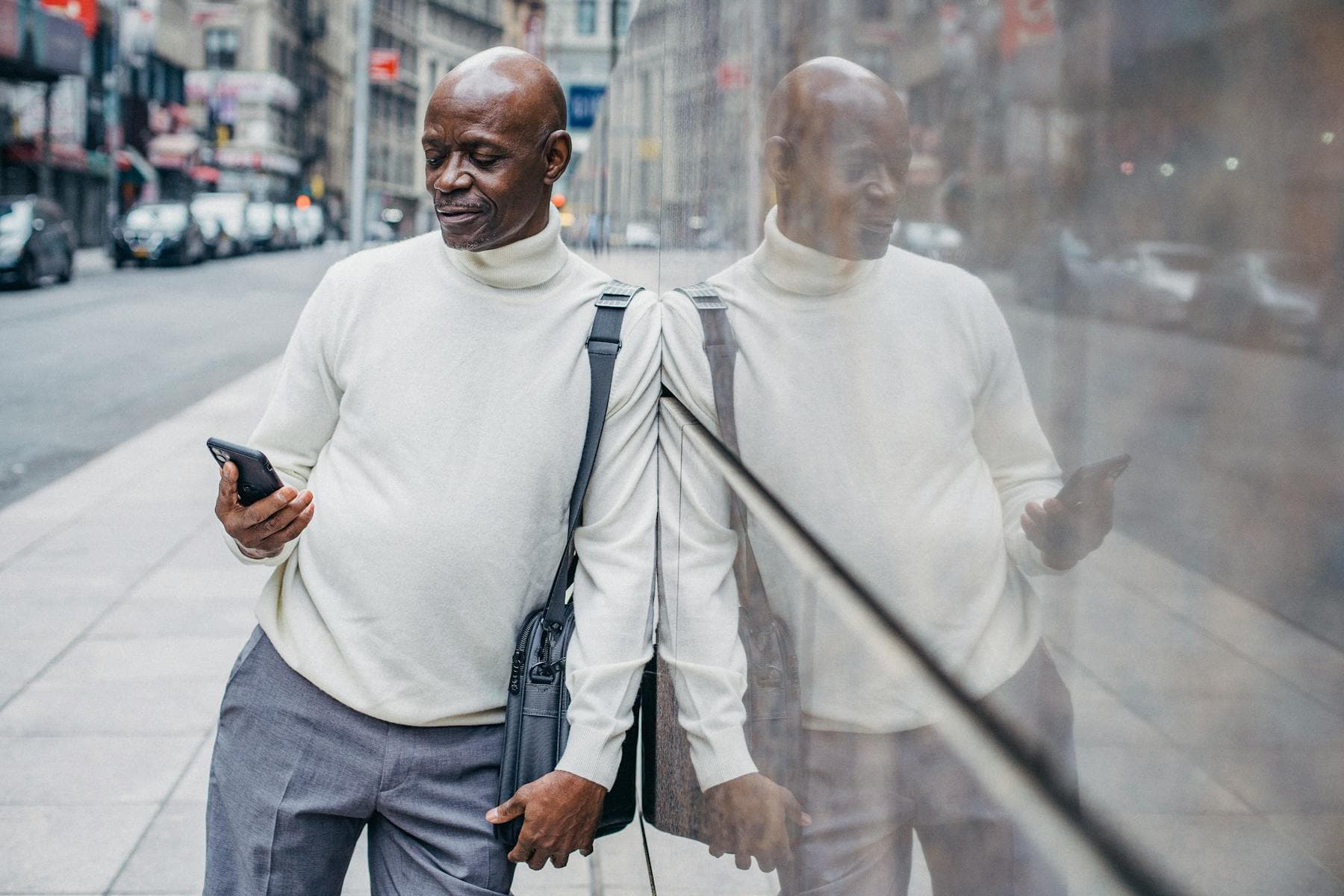 Black businessman using his phone in the city, reflecting the real-world context where financial trust gets earned before any product is believed.